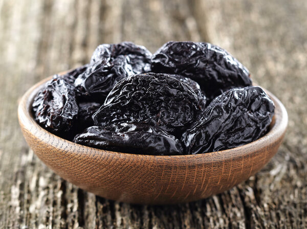 Prune on a wooden background