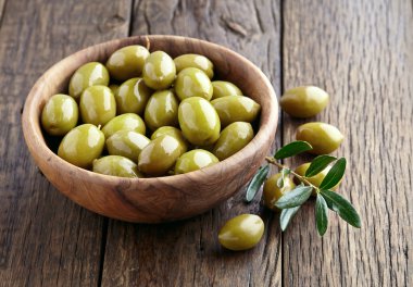 Green olives on a wooden background clipart