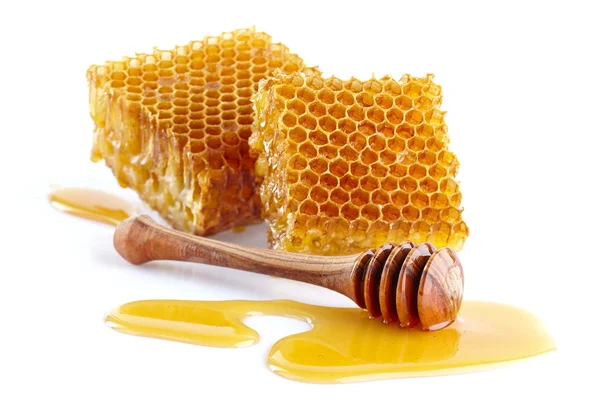 Pentes de mel com colher de madeira — Fotografia de Stock