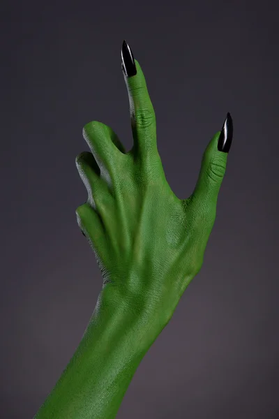 Зеленая рука ведьмы с острыми черными ногтями — стоковое фото