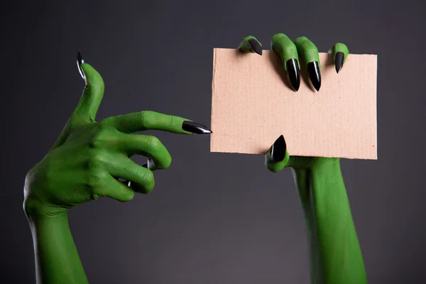 Mãos verdes monstro segurando pedaço vazio de papelão — Fotografia de Stock