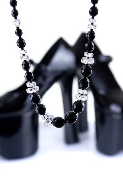 Pair of black platform shoes with necklace — Stock Photo, Image