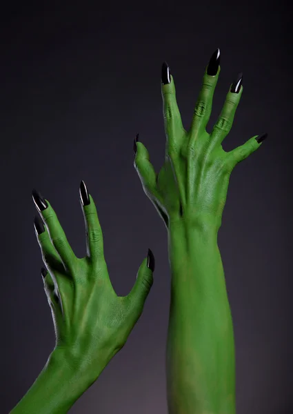 Monstre vert mains avec des ongles noirs étirant vers le haut — Photo