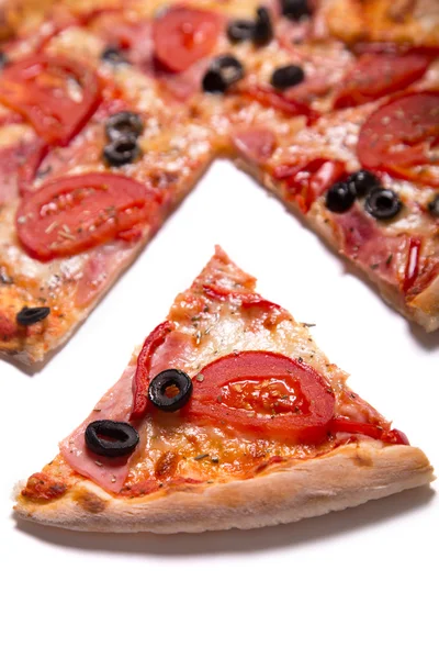 Pizza saborosa com presunto, tomates e azeitonas com uma fatia removida — Fotografia de Stock