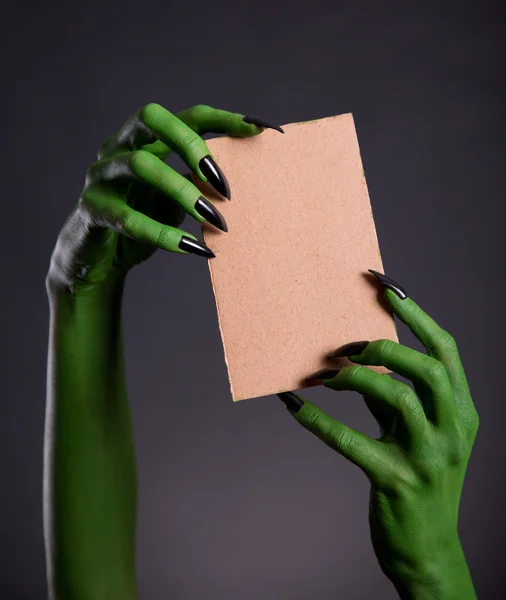 Grüne Monsterhände mit leerem Stück Pappe — Stockfoto