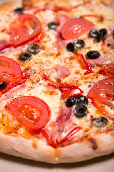 Close-up de deliciosa pizza italiana com presunto, tomate e — Fotografia de Stock