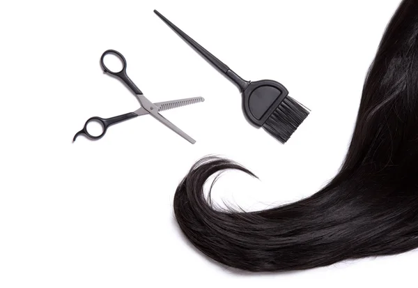 Black hair with scissors and dye brush — Stock Photo, Image