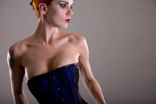 Sensuele redhead vrouw in blauwe korset — Stockfoto