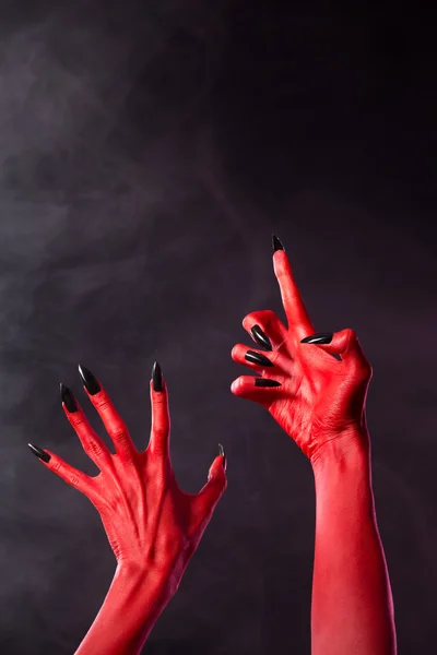 Red devil händer med svarta naglar — Stockfoto