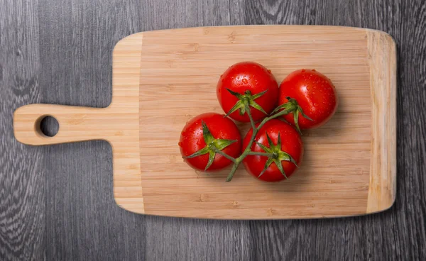 Tomates frescos em tábua de cortar — Fotografia de Stock