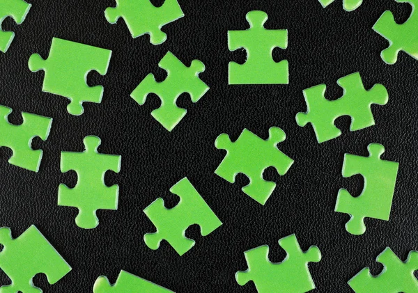 Green puzzles on black leather