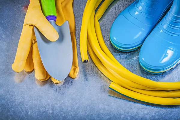 Rubberen laarzen, slang, handschoenen en spade — Stockfoto