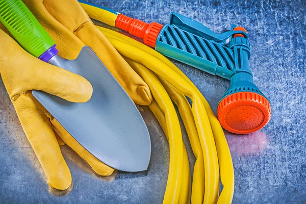 Garden hose, water sprayer and gloves — Stock Photo, Image