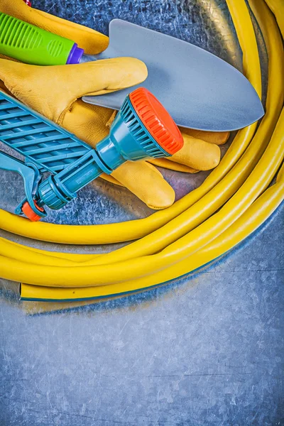 Garden hose, safety gloves and spade — Stock Photo, Image