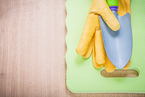 Beschermende handschoenen, hand spade en pad — Stockfoto