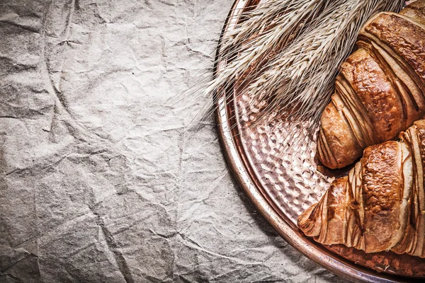 Пшеничные и ржаные уши и круассаны — стоковое фото
