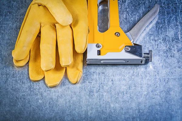 Leather protective gloves and straple gun — Stock Photo, Image