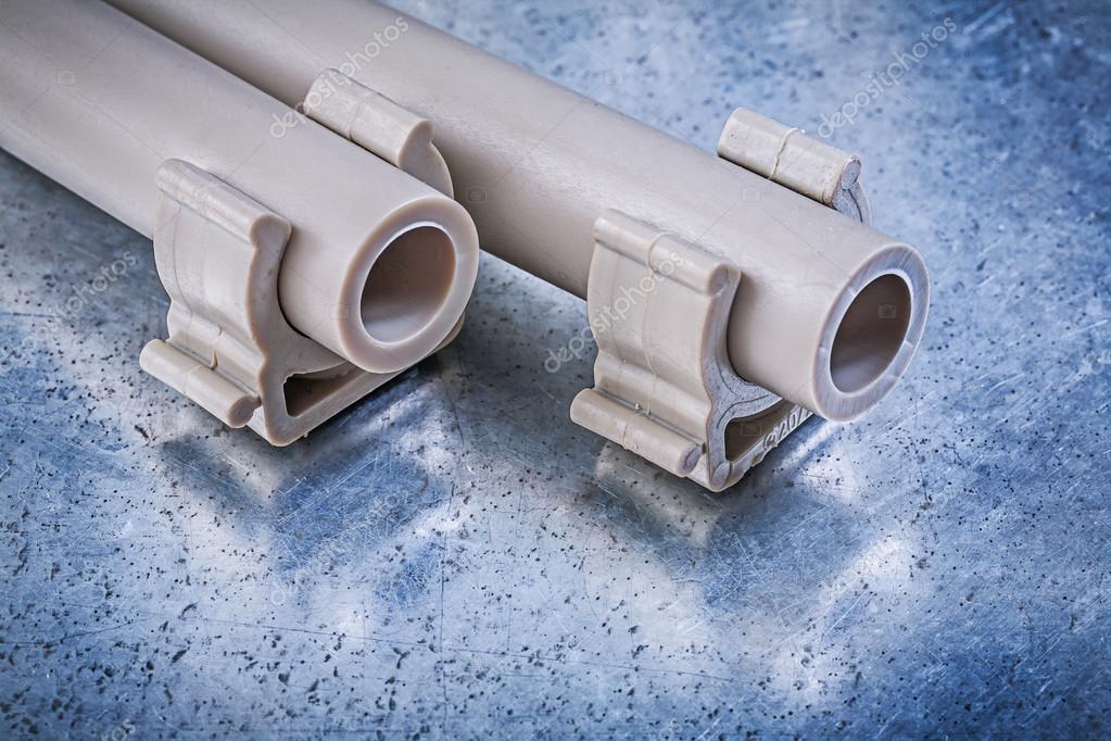 Plastic water tubes and pipe clamps Stock Photo by ©mihalec 105683208