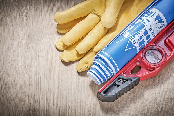 Protective gloves, construction level and blueprints — Stock Photo, Image