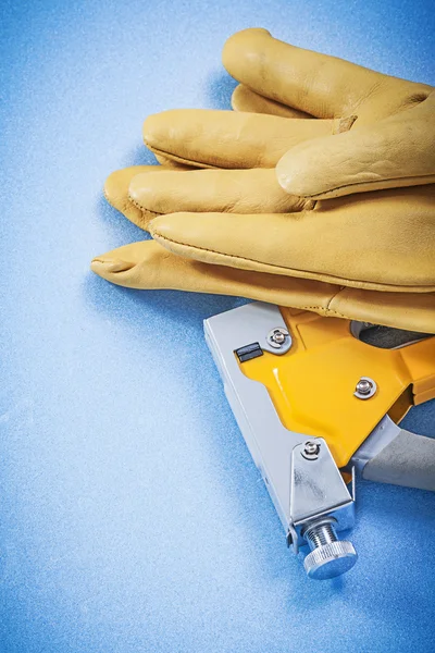 Leather protective gloves and construction stapler — Stock Photo, Image