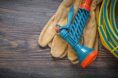 El ahşap tahta üzerinde Bahçe lastik hortum koruyucu eldiven püskürtme