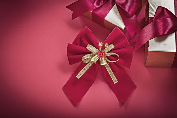 Noel düğüm giftboxes kırmızı arka plan tatil konsantrasyon üzerinde sarılı. — Stok fotoğraf