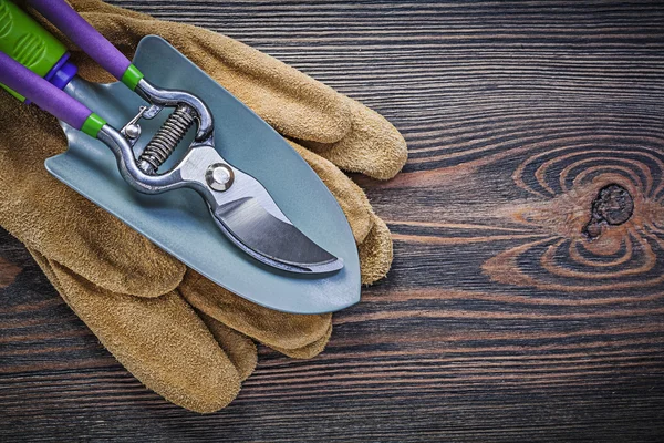 Hand spade garden pruner protective gloves on wooden board garde — Stock Photo, Image