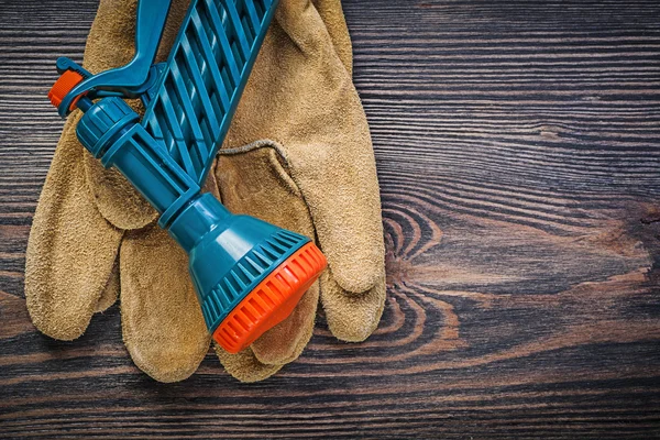 Garden hose nozzle safety gloves on wooden board agriculture con — Stock Photo, Image