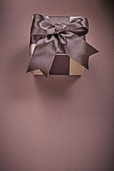 Gift box on brown surface vertical image holidays concept — Stock Photo, Image