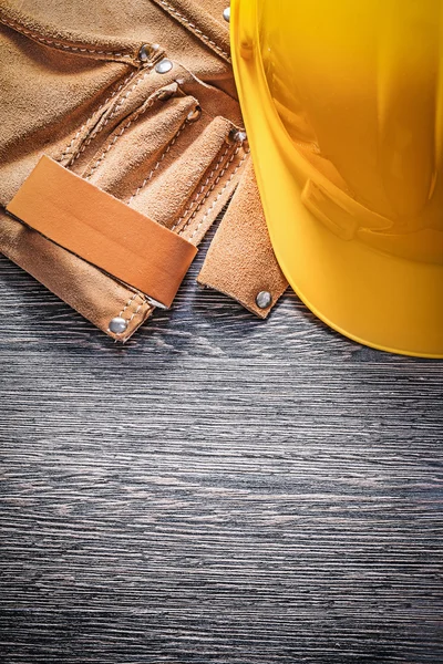 Leather tool belt building helmet on wooden board construction c