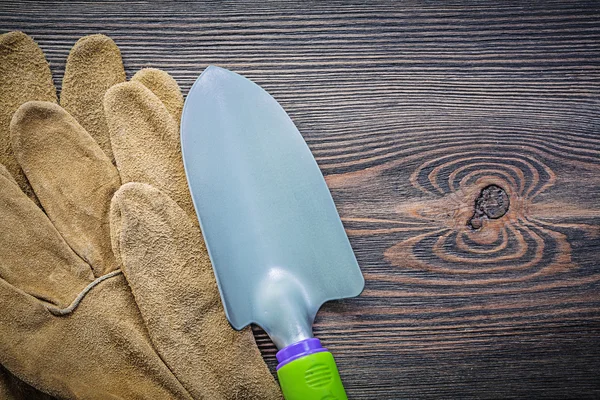 Hand spade pair of protective gloves on wooden board gardening c — Stock Photo, Image