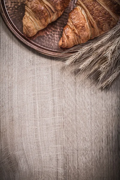 Vassoio di rame croissant per le orecchie di segale di grano dorato su tavola di legno — Foto Stock