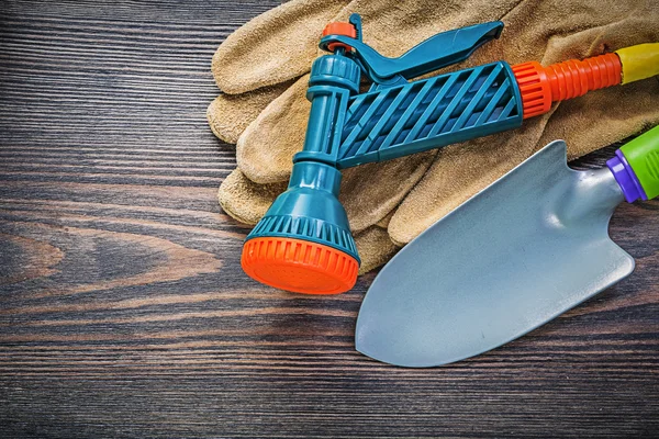 Tuin spray nozzle veiligheidshandschoenen hand spade op houten plank agr — Stockfoto