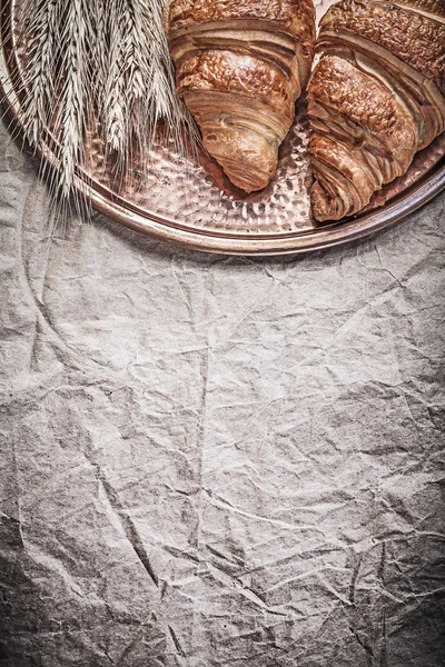 Hojas de centeno de trigo maduro bollos dulces bandeja de cobre en papel de embalaje —  Fotos de Stock