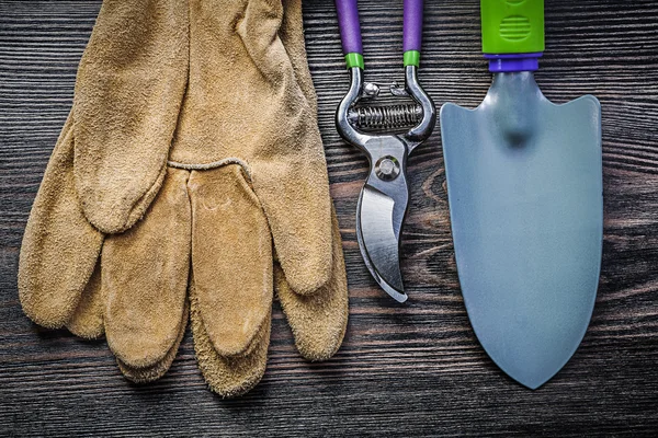 Pá secateurs luvas de segurança de couro na madeira placa de jardinagem c — Fotografia de Stock