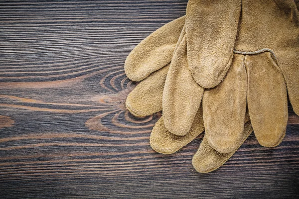 Par av läder skyddshandskar på vintage träskiva trädgårdsskötsel — Stockfoto
