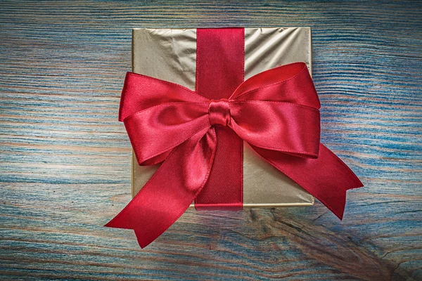 Подарункова коробка з червоною стрічкою на старовинній дерев'яній дошці святкові примари — стокове фото