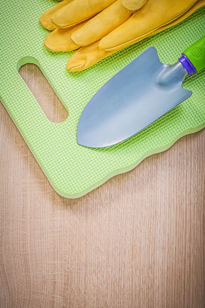 Veiligheidshandschoenen tuin schuim knielende pad hand spade op houten zwijnen — Stockfoto