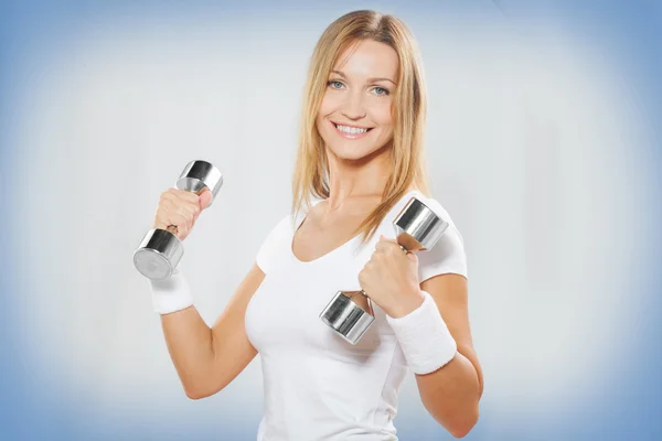 Young sportswoman holding dumbbells — Stock Photo, Image