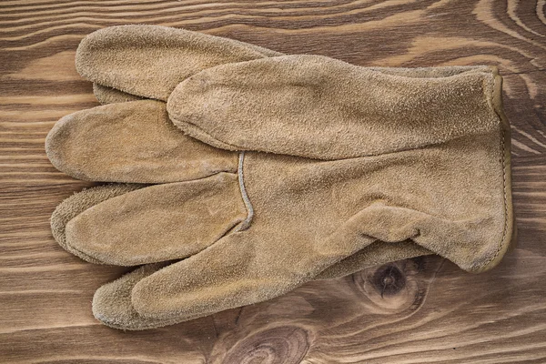 Safety gloves on vintage wooden board — Stock Photo, Image