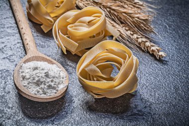 Buğday çavdar kulakları tahta kaşık un ham sarmal makarna fettuccine üzerinde
