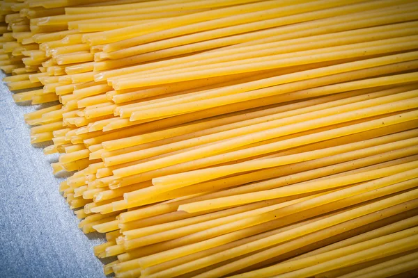 Heap of thin spaghetti on blue background directly above food an — Stock Photo, Image