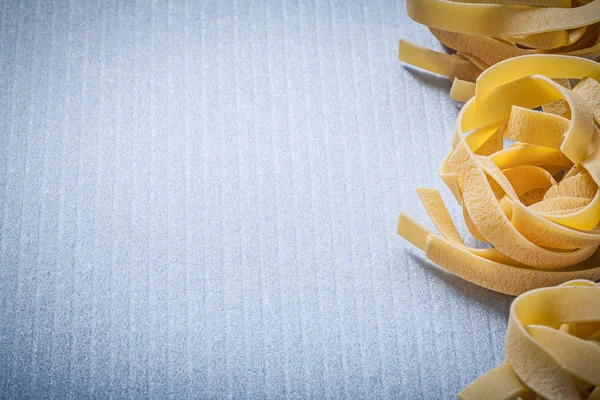 Kopierraum von gerollten Nudeln fettuccine auf blauem Hintergrund Lebensmittel ein — Stockfoto