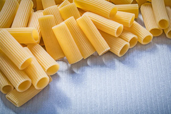 Stapel ungekochter Pasta auf blauem Hintergrund Essen und Trinken concep — Stockfoto