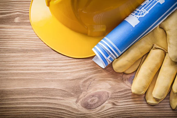 Blue rolled blueprint building helmet safety gloves on wooden bo — Stock Photo, Image