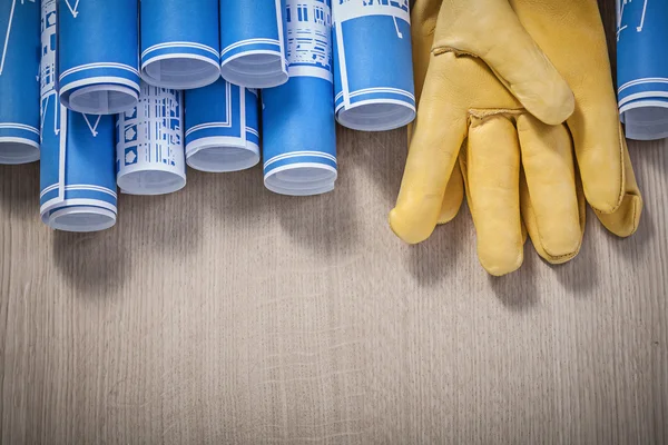 Azul enrolado planos de construção luvas de segurança de couro no woode — Fotografia de Stock