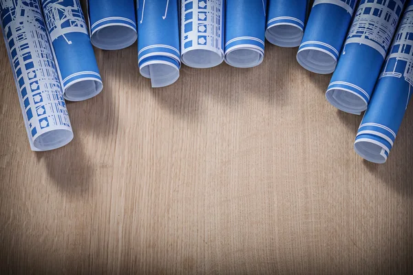 Sammlung blau gerollter Konstruktionszeichnungen auf Holztafel — Stockfoto