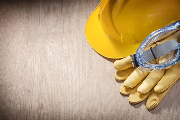 Samenstelling van handschoenen bril van de veiligheid van de helm op houten bord — Stockfoto