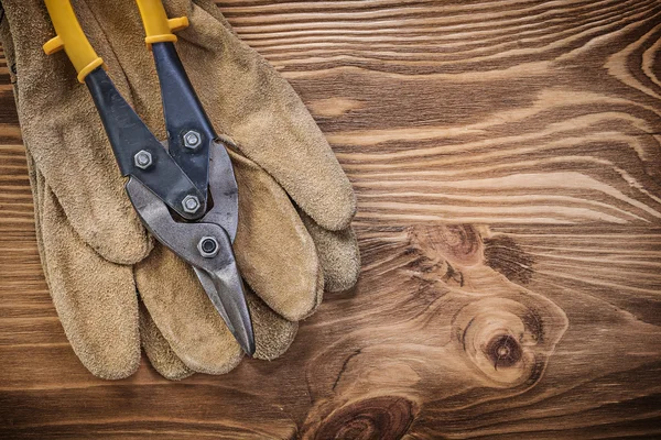 Luvas de segurança de couro de estanho snips na construção de placa de madeira vintage — Fotografia de Stock