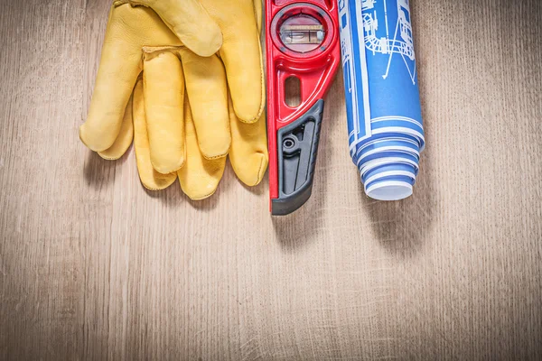 Safety leather gloves construction level rolled blue blueprints — Stock Photo, Image